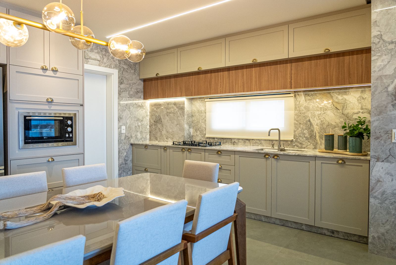 Cozinha contemporânea com aéreos amadeirados e pedra cinza